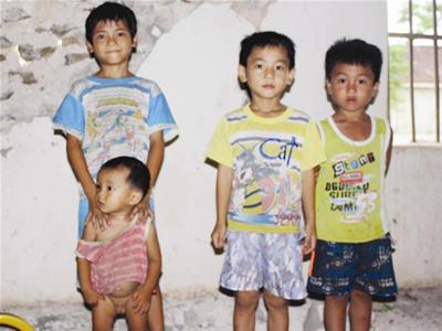 Các em học sinh bên bức tường sắp đổ