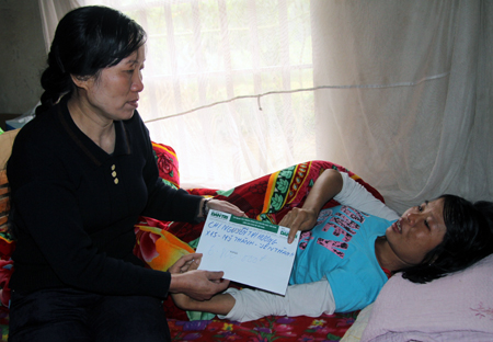 qBà Phan Thị Tâm - Chủ tịch Hội phụ nữ xã trao quà bạn đọc Dân trí tới chị Nguyễn Thị Hương.